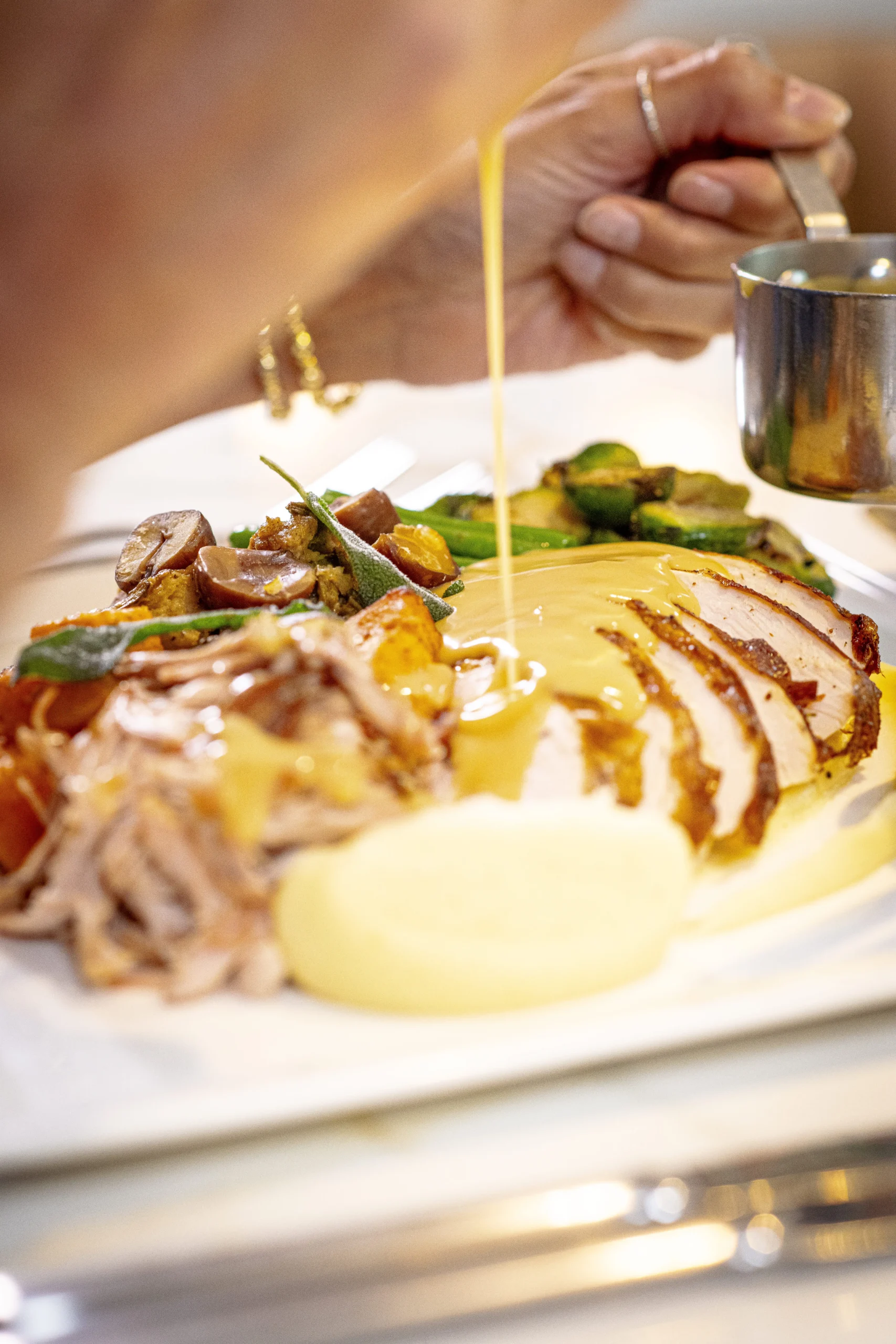 Gravy poured over roast turkey and holiday sides
